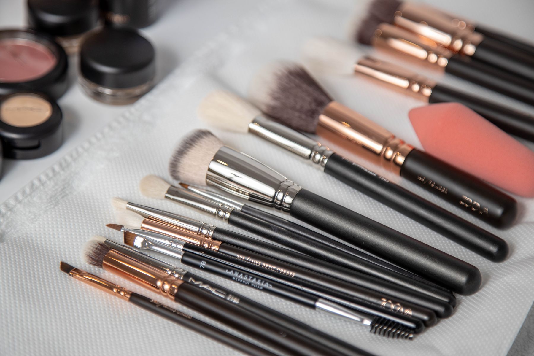 Real makeup brushes of several sizes arranged on a white towel